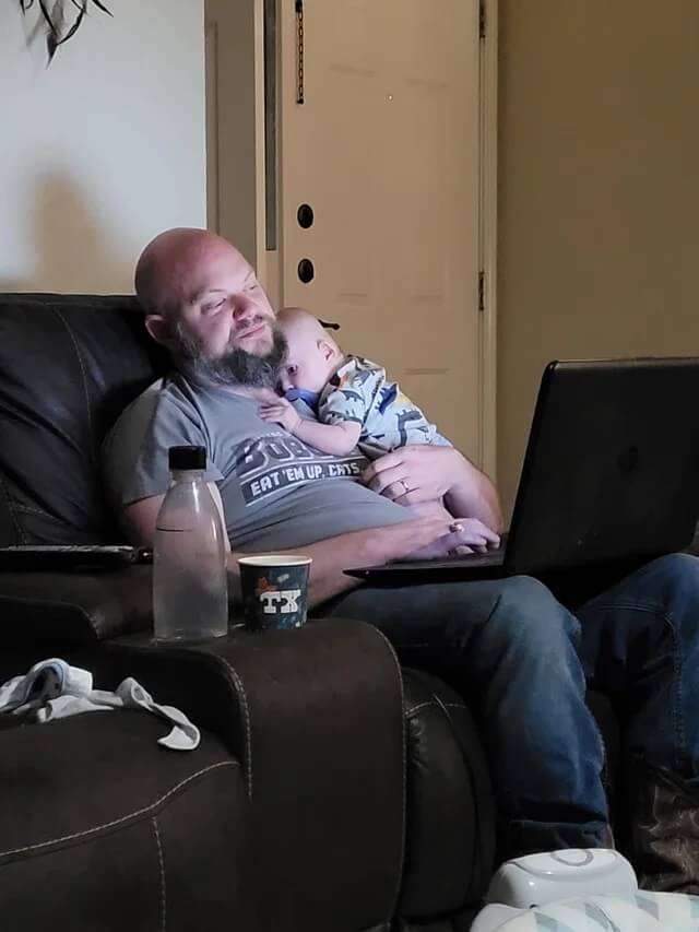 My husband working on his Masters degree while holding one of our twin boys