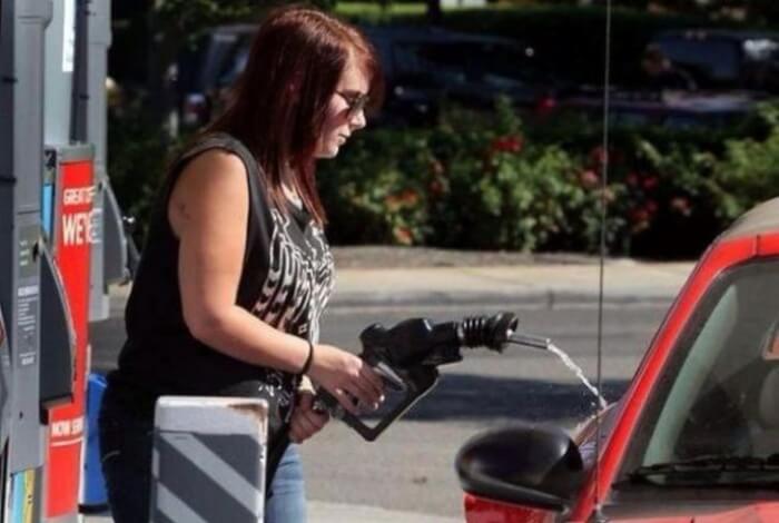 Silly girl pumping gas