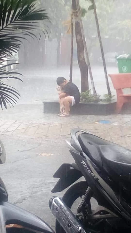 Boy Tightly Hugs His Dog Under The Rain